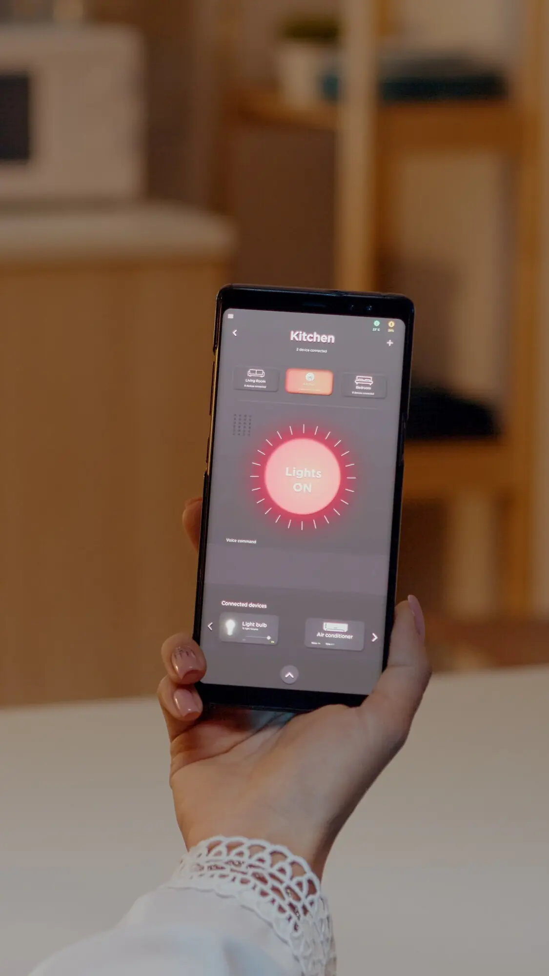 Eine Frau hält ein Smartphone mit einer App zur Beleuchtungssteuerung.